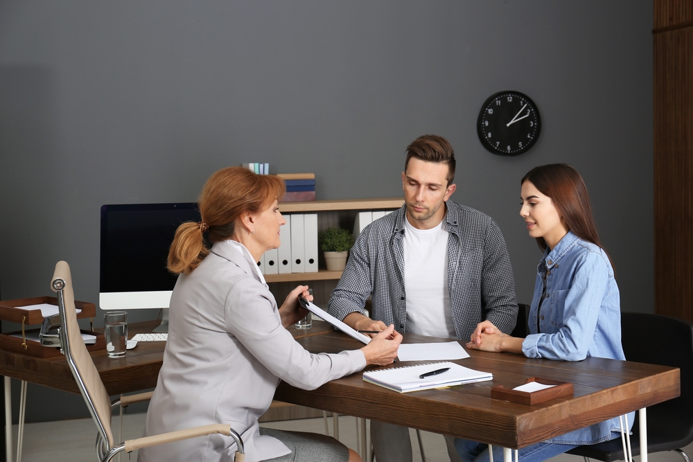 Lawyer Having Meeting With Young Couple In Office